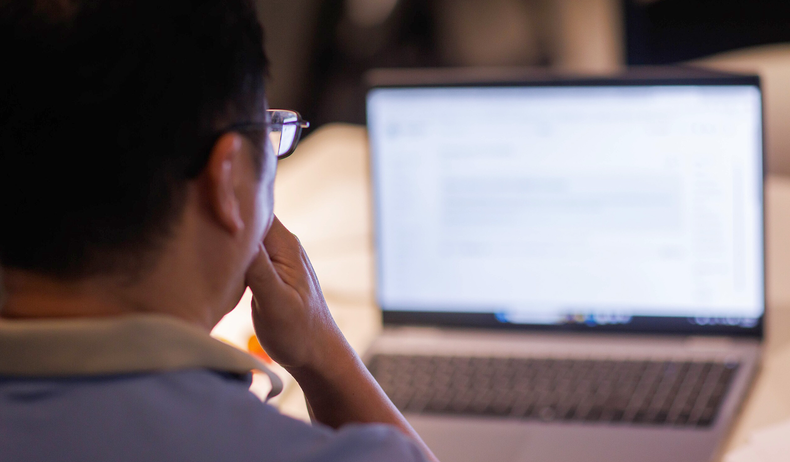 Photo of man looking at his computer screen