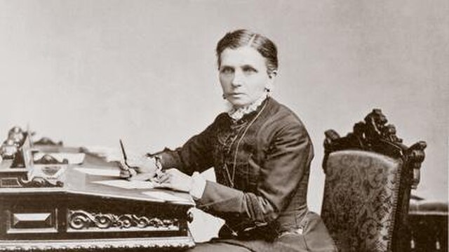 Old photo of a woman writing at her desk